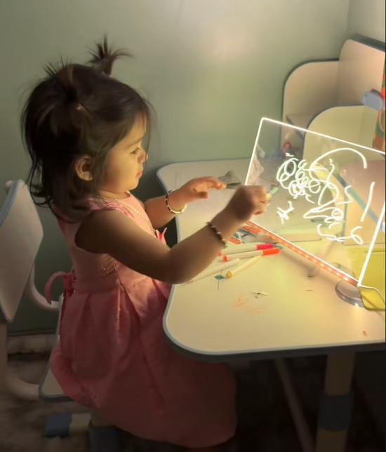 Grandchild drawing on glowing board